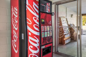 Eine Coca-Cola-Getränkeautomaten mit einer Auswahl an Getränken und einem digitalen Bildschirm.