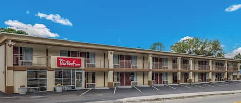 Un hotel Red Roof Inn de dos pisos, con varios balcones y un estacionamiento.