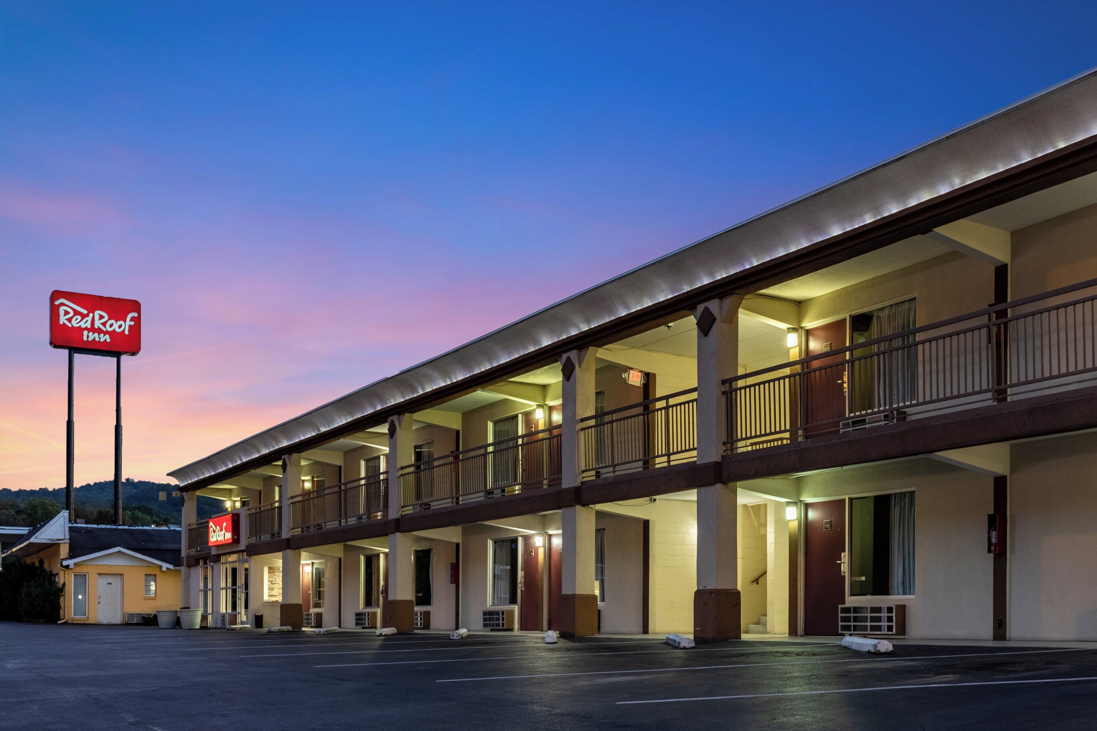 Un hotel Red Roof Inn de dos pisos, con varios balcones y un estacionamiento.