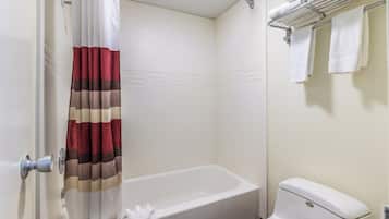Un baño con bañera, inodoro y perchero para toallas.