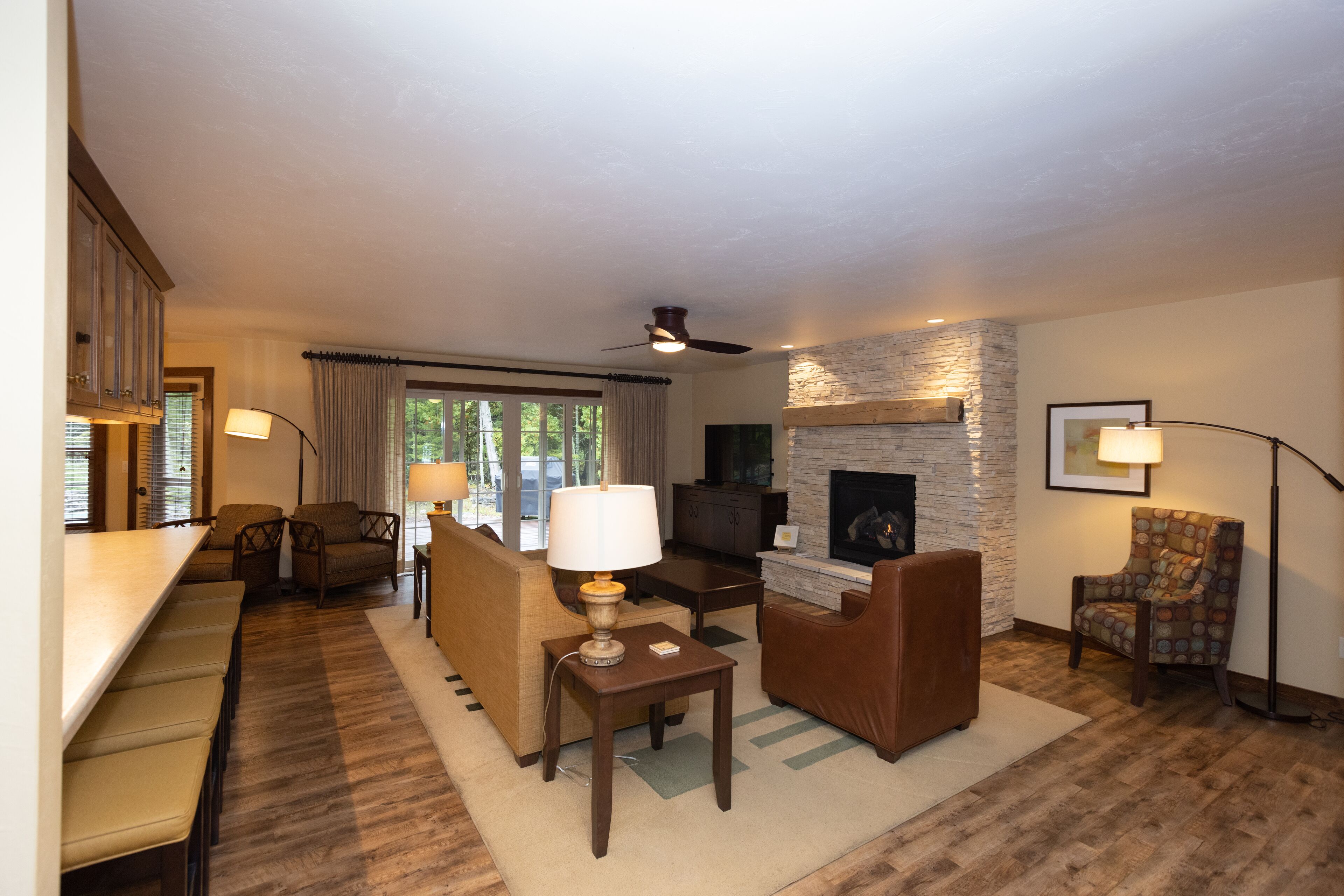 A spacious living room with a fireplace, comfortable seating, and a dining area.