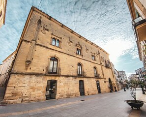 Un edificio histórico de piedra con numerosas ventanas y una entrada central.