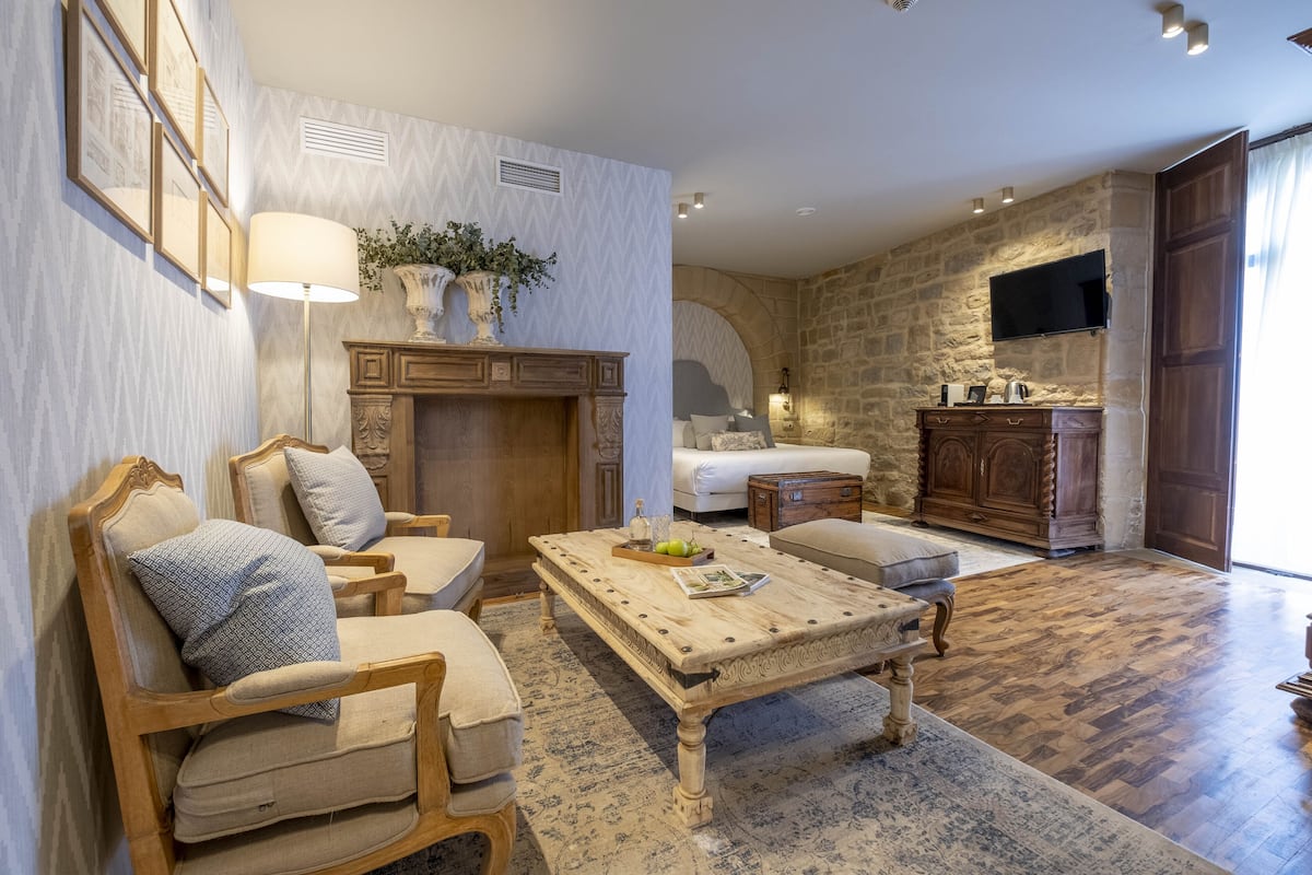 A spacious living room with a fireplace, comfortable seating, a coffee table, and a stone accent wall.