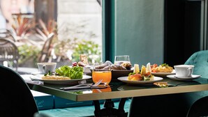 A table with various breakfast items including pastries, fruits, and beverages.