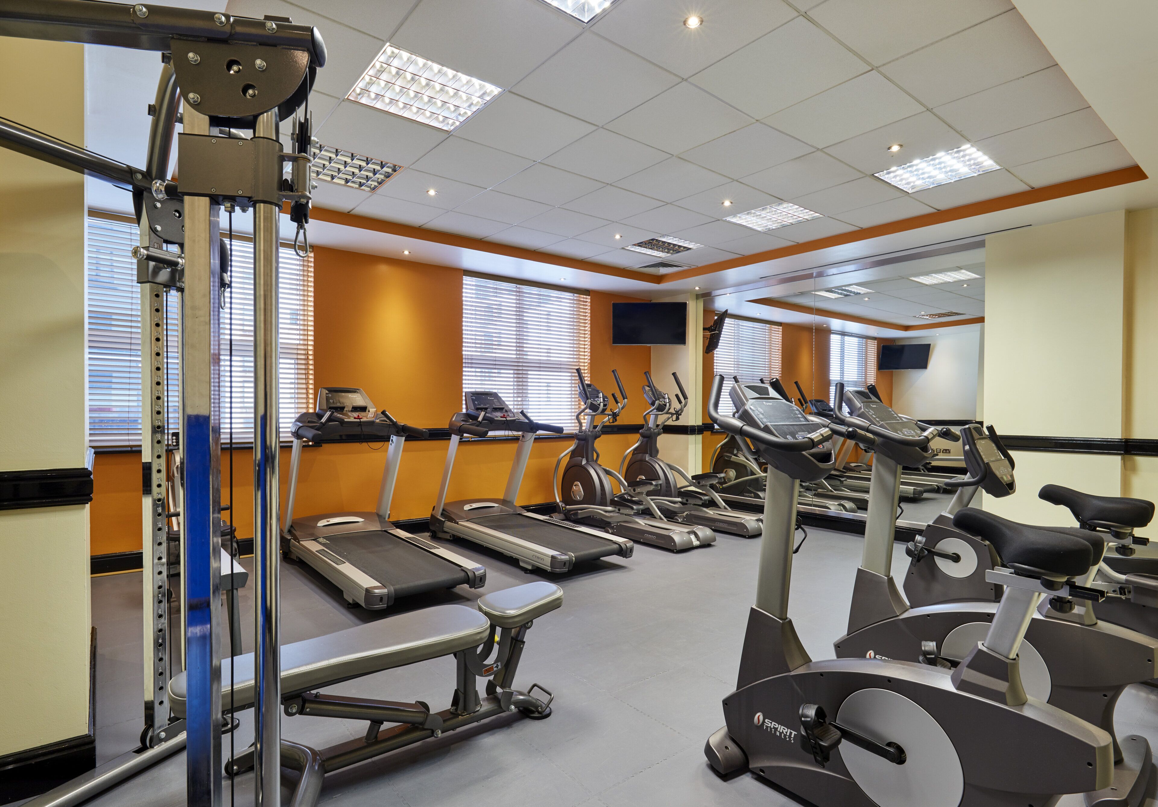 A gym with multiple treadmills, stationary bikes, and exercise equipment.