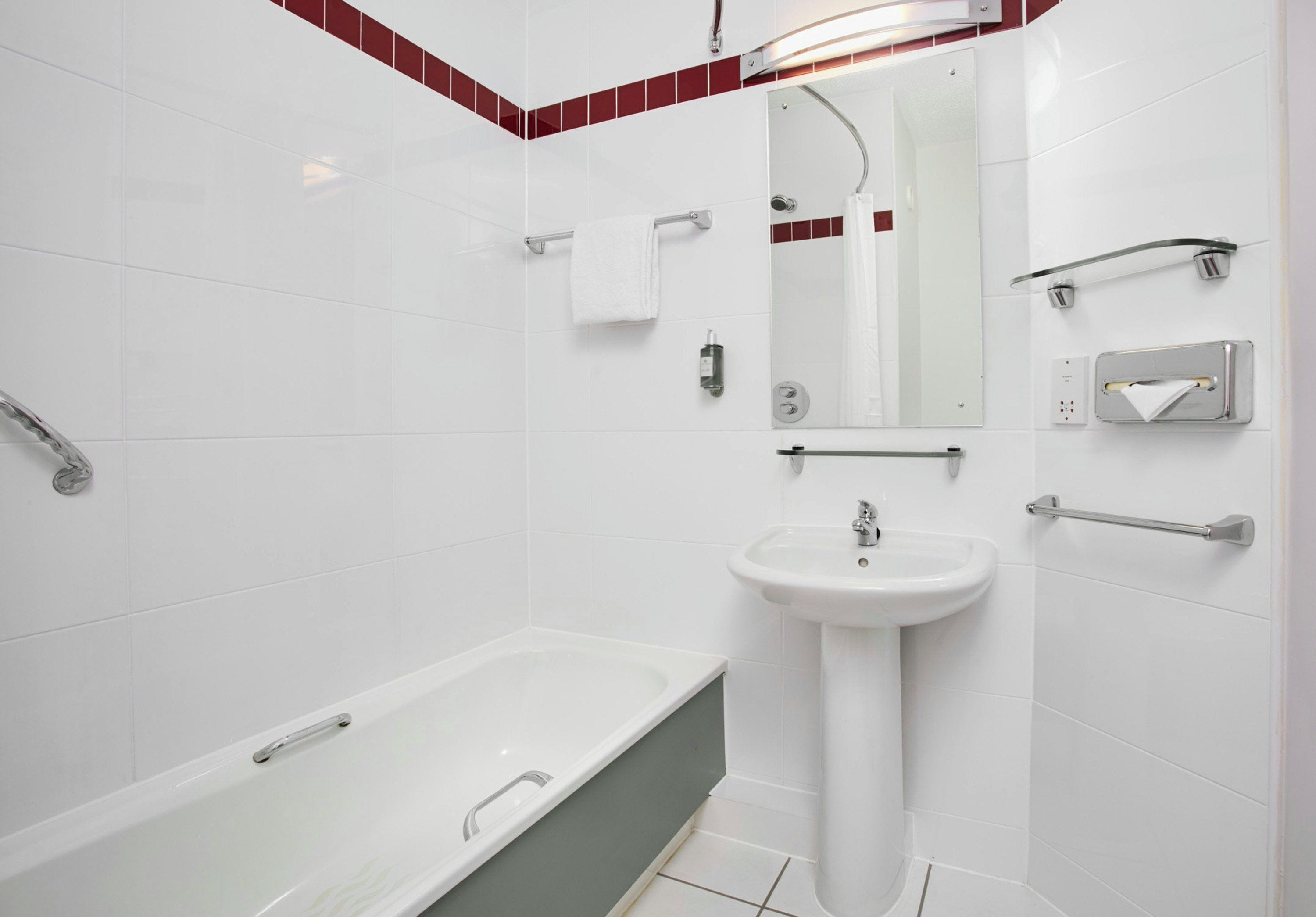 A modern bathroom with a bathtub, a sink, and a shower area.