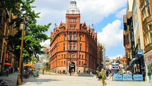 A historic building with a prominent tower, a central entrance, and a surrounding urban street with shops and pedestrians. - Leonardo Hotel Nottingham  (Nottingham)
