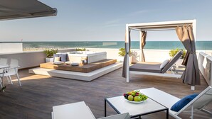 Una terraza en la azotea con zona de estar, una mesa con fruta y vistas al mar.