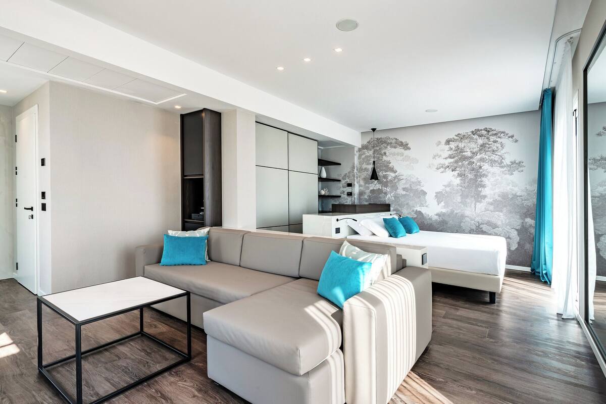 A modern living room with a sectional sofa, a small table, and built-in storage.
