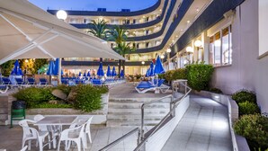 Ein Hotel-Atrium mit Außenbereich, Treppe und Pool.