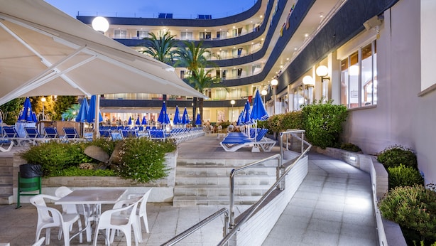 Een hotelatrium met buiten zitplaatsen, een trap en een zwembad.