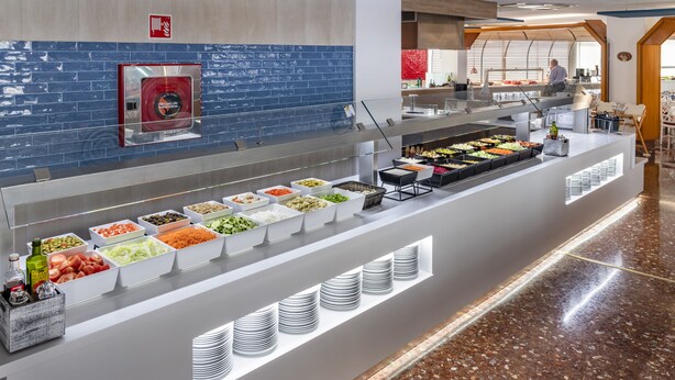 Ein Buffet mit verschiedenen Speisen und einem an der Wand befestigten Feuerlöscher.