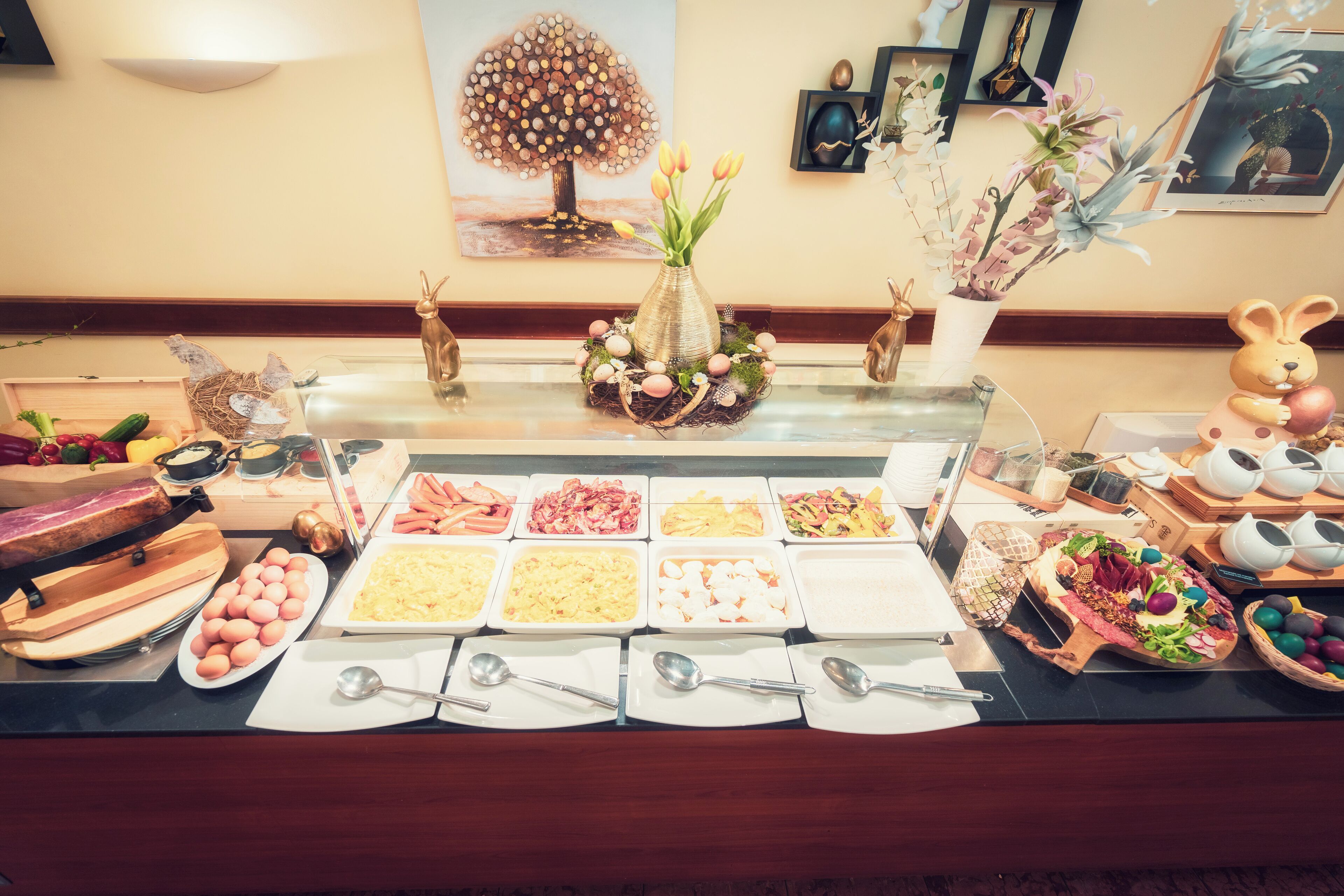 A buffet with various food items and a decorative centerpiece.