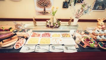 Buffet com diversos alimentos e um arranjo decorativo.