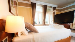 A hotel room with a large bed, a television, and a window with curtains. - BRISTOL Hotel Opatija (Opatija)