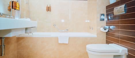 A modern bathroom with a bathtub, toilet, and sink.