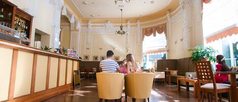 A spacious lobby with a bar area, seating arrangements, and decorative elements.
