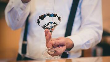 A person holding a wine glass with a unique, wavy design.