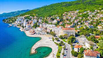 A coastal town with a curved bay, buildings, and a road along the waterfront.