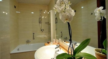 A bathroom with a bathtub, a sink, and a mirror.