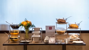 A buffet setup with various food containers and a sign indicating selection of dried fruit. - Magris Hotel (Naples)