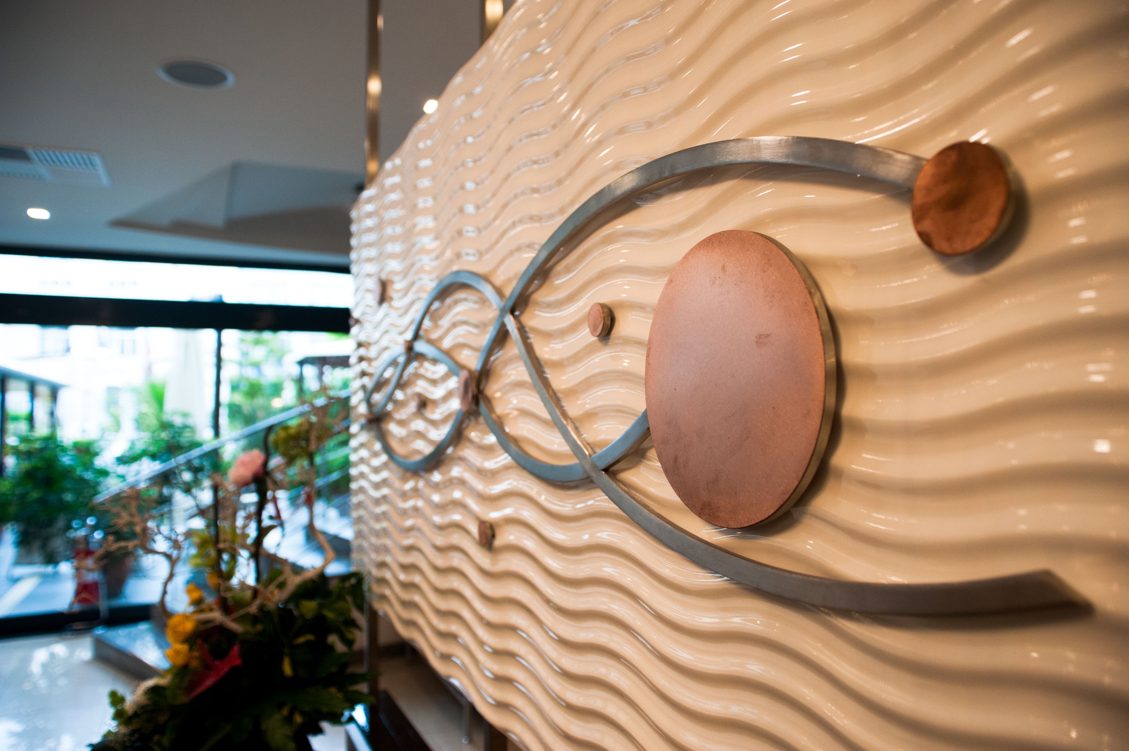 A textured wall with a wavy pattern and two circular metallic elements.