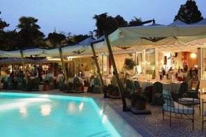 Una piscina al aire libre, sombrillas, tumbonas