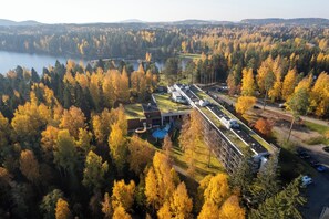 An aerial view of a campground with RVs, a swimming pool, and a building with a green roof.