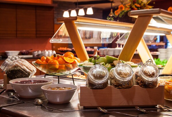 A buffet setup with various food items and condiments.