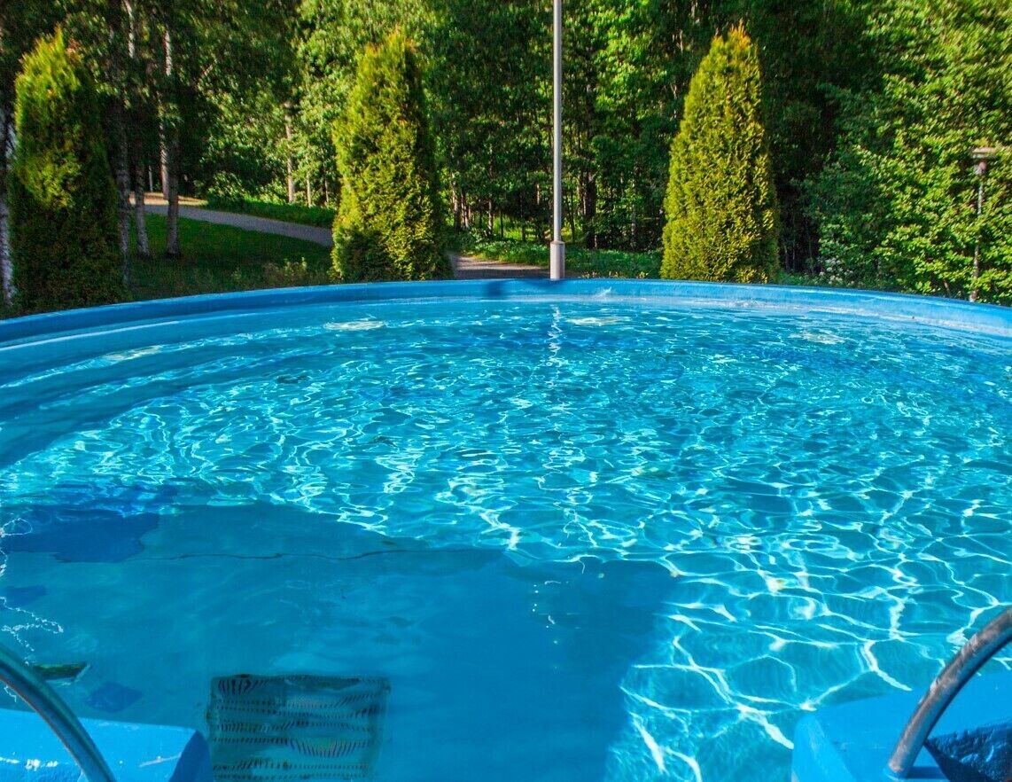 Una piscina azul cristalina rodeada de exuberante vegetación.