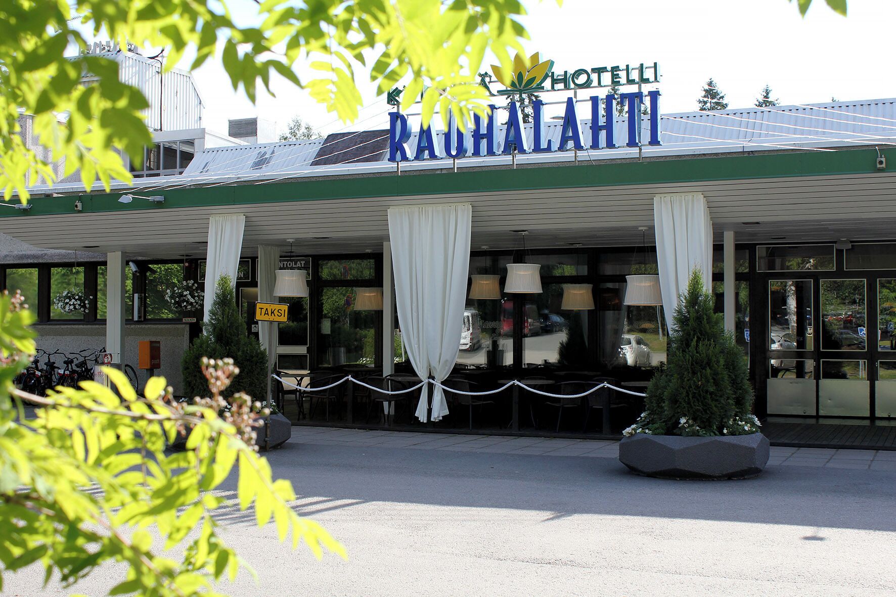 A hotel with a sign reading "HOTEL RAHALAHITI" and a sign for "TAKSI".