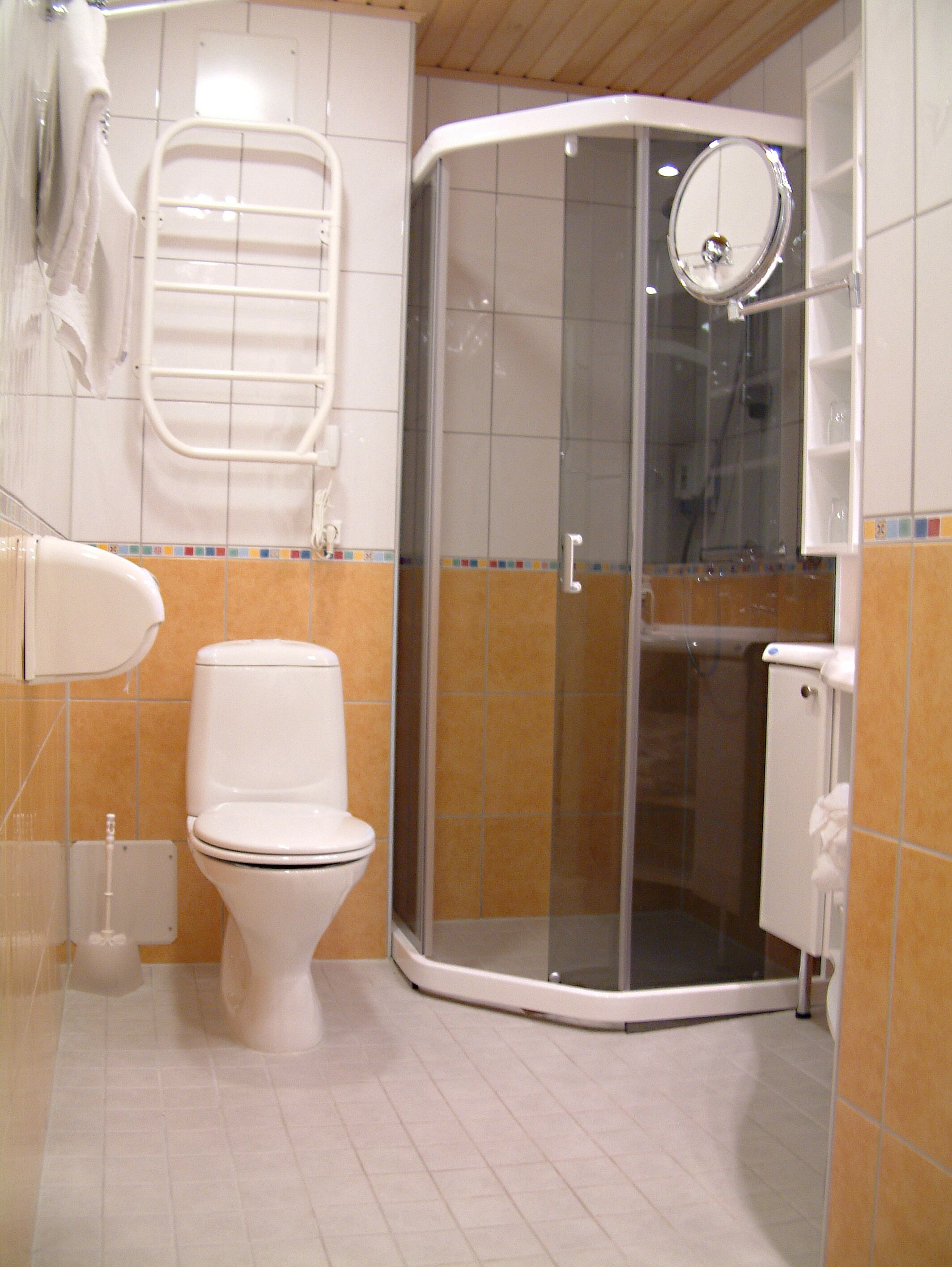 A bathroom with a toilet, a shower enclosure, and a towel rack.