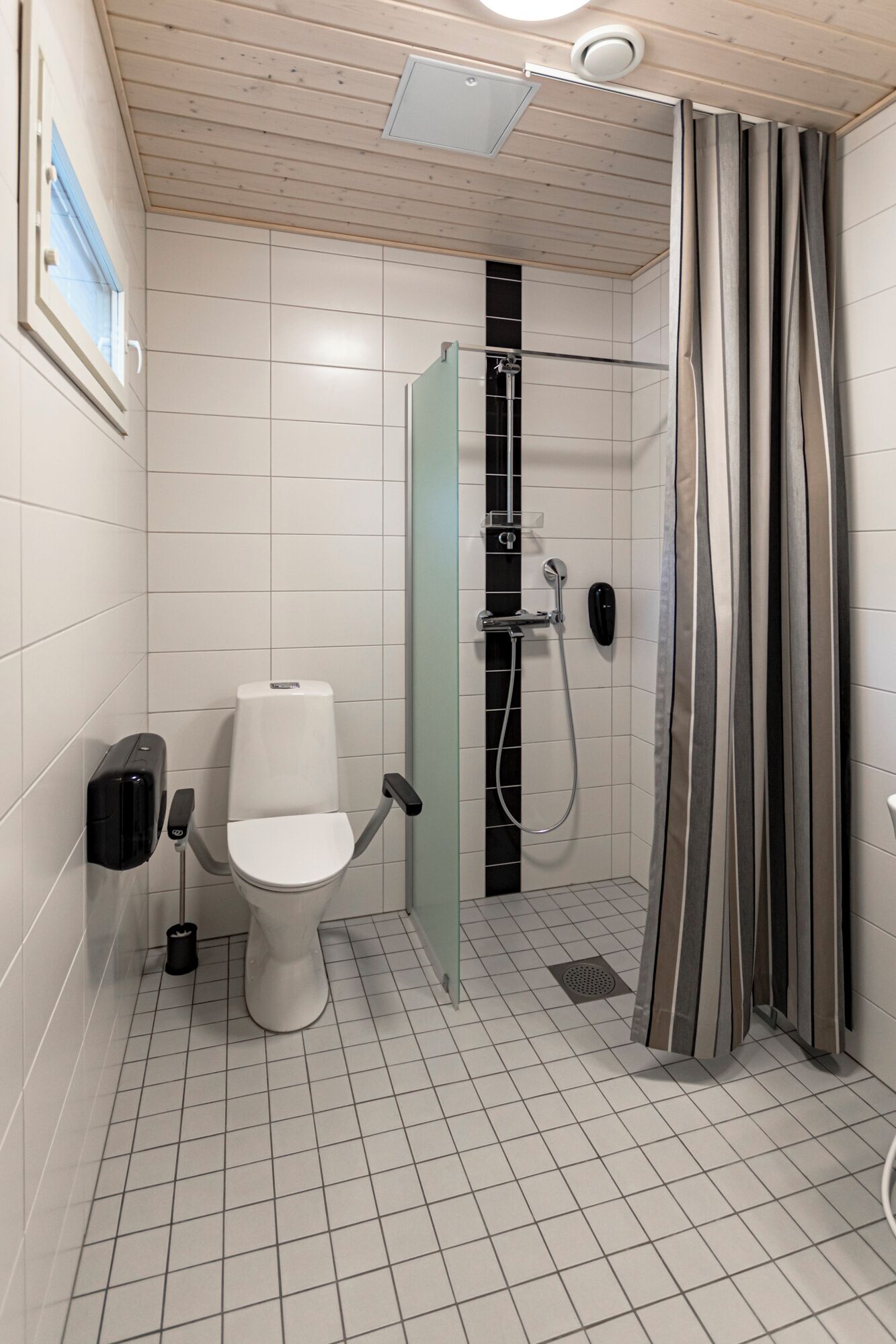 Un baño moderno con inodoro, ducha y mampara de vidrio.