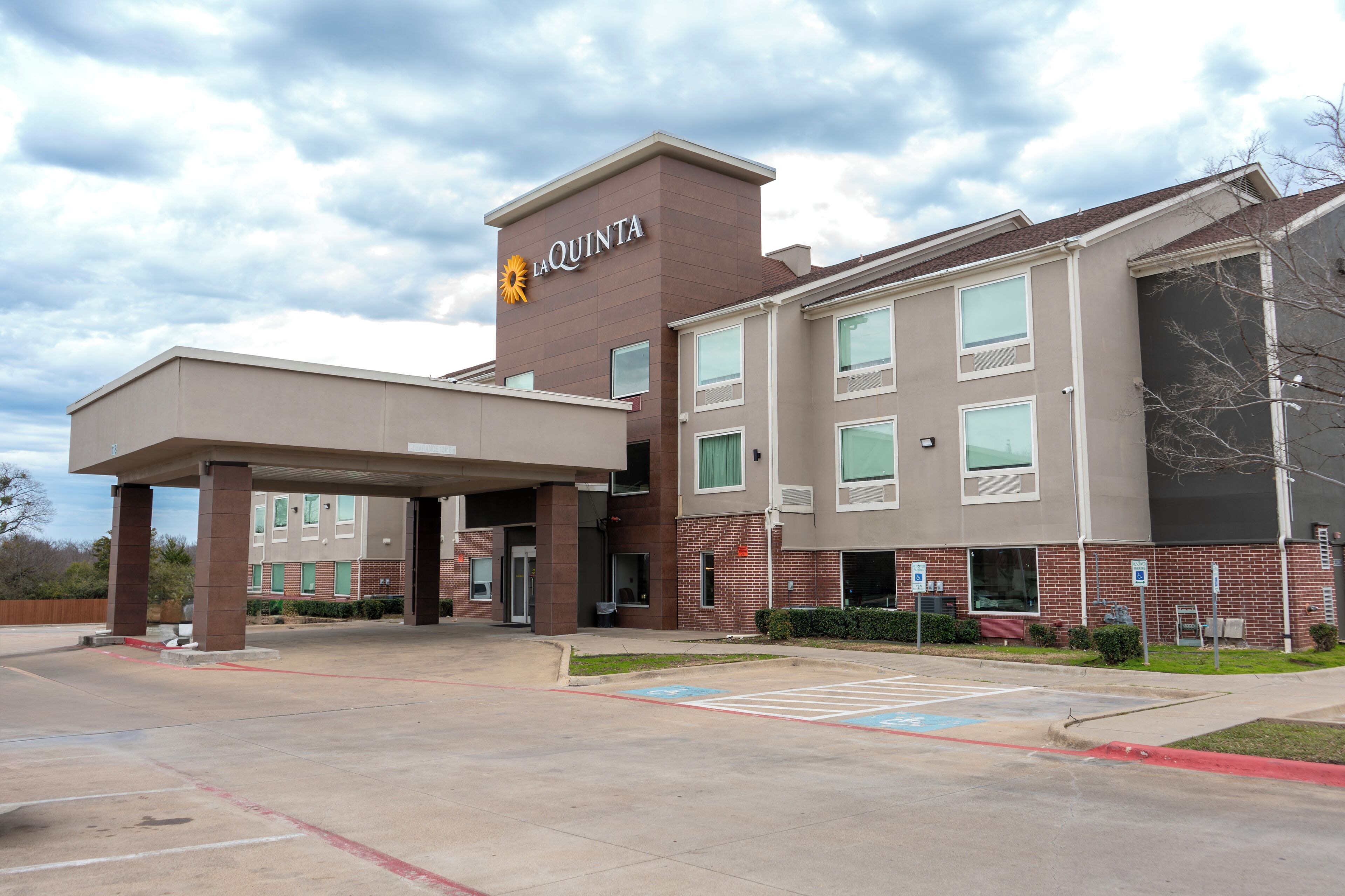 A La Quinta hotel with a covered entrance, multiple windows, and a parking lot.