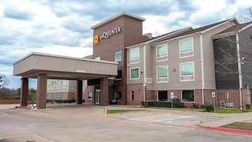 Un hôtel La Quinta doté d’une entrée abritée, de nombreuses fenêtres et d’un parking.