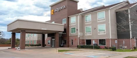 A La Quinta hotel with a covered entrance, multiple windows, and a parking lot.