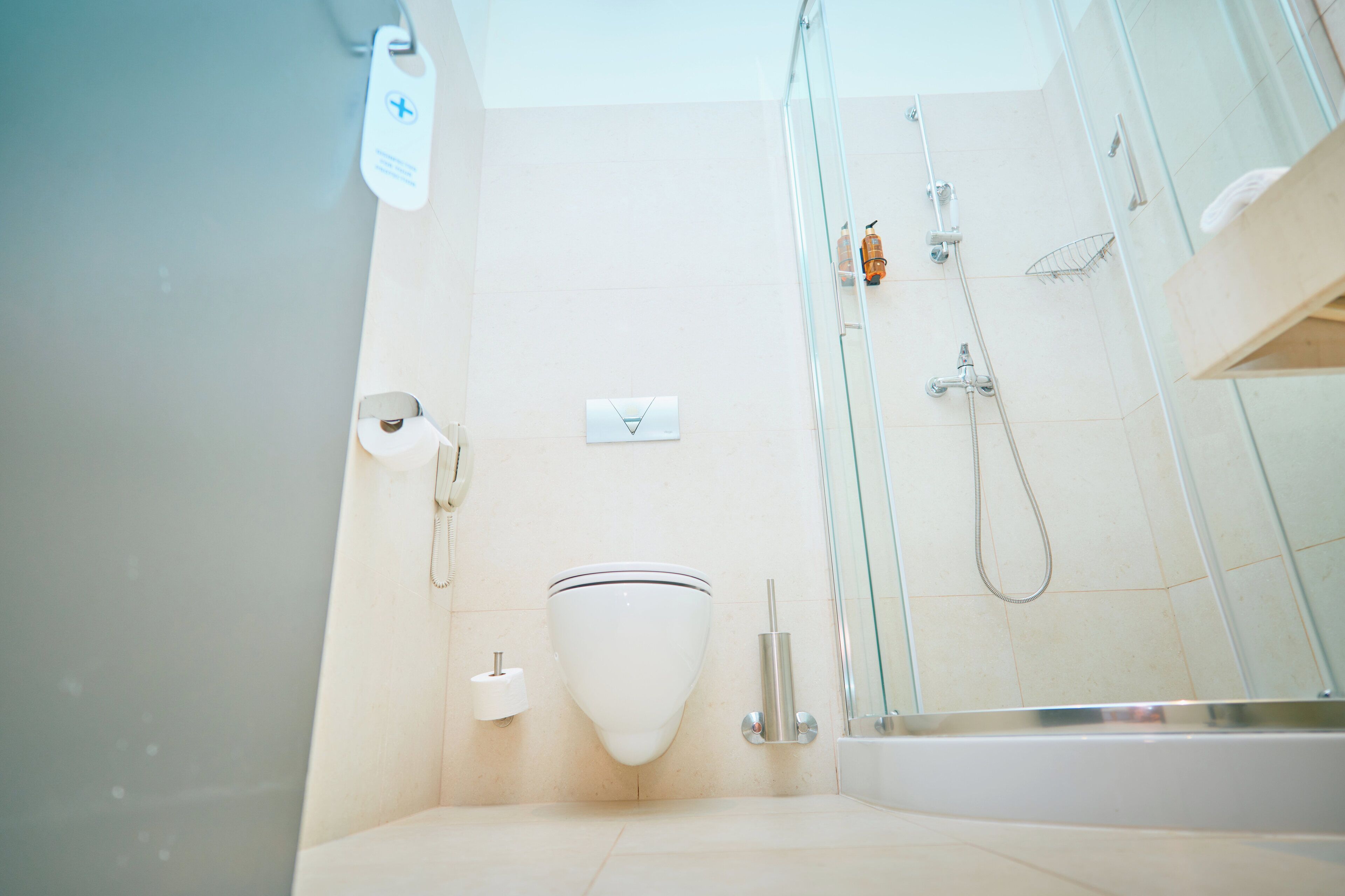 A modern bathroom with a toilet, bidet, and glass-enclosed shower.