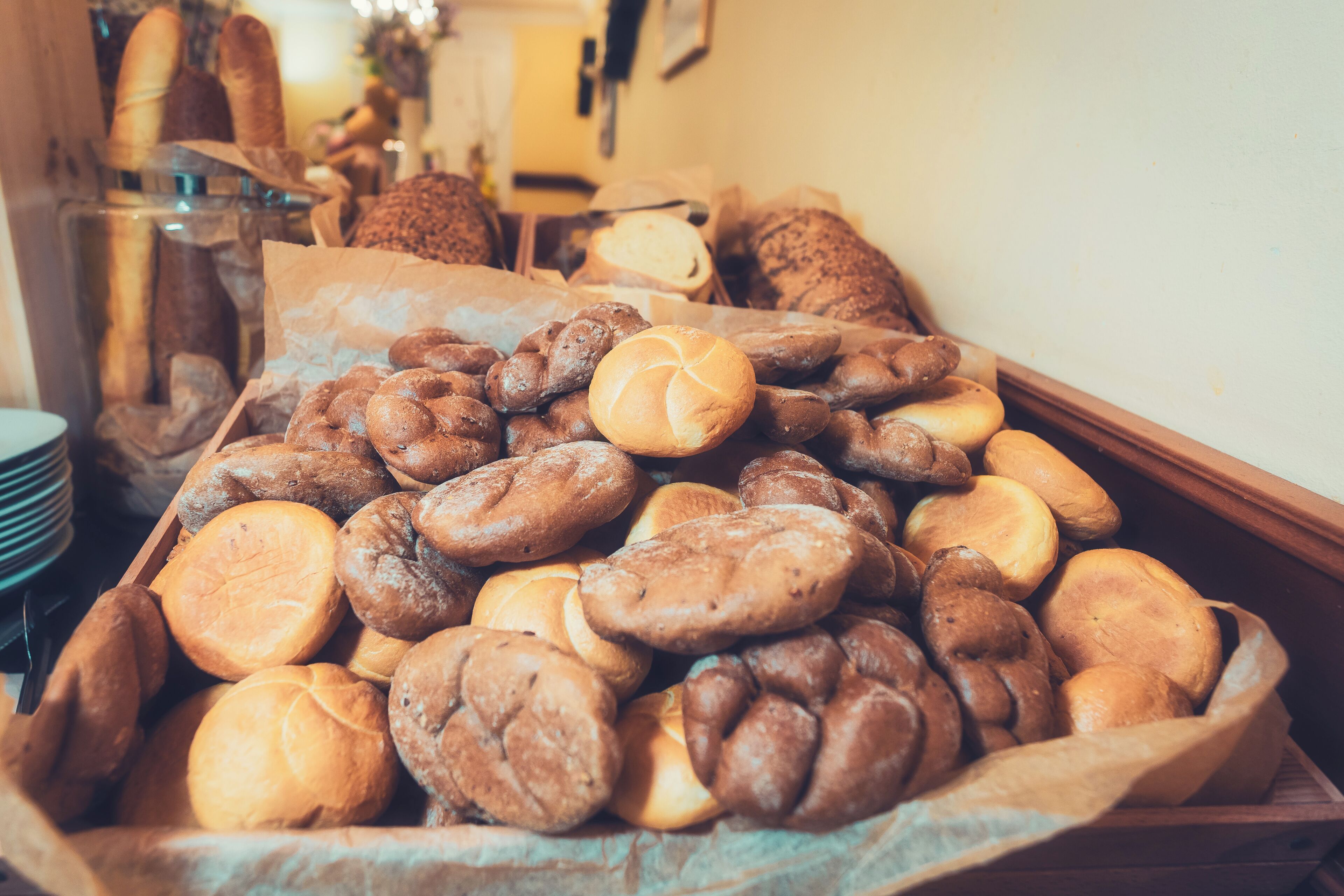 Un assortiment de pains et de viennoiseries dans un panier en bois.
