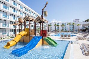 Una piscina al aire libre, sombrillas, tumbonas
