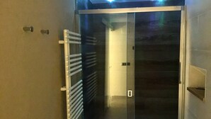 Un ascenseur moderne doté d’une porte en verre et d’une rampe métallique.