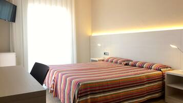 Une chambre d’hôtel avec un lit, un bureau et une télévision.