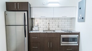 Een moderne keuken met een roestvrijstalen koelkast, een magnetron en een spoelbak met een kraan.
