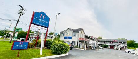 A Haven Inn & Suites building with a prominent sign, a parking lot, and a Liberty Inn sign in the background.