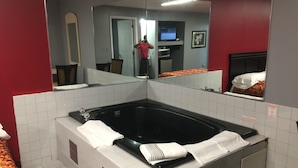 Un baño con un espejo grande, una bañera y un inodoro.