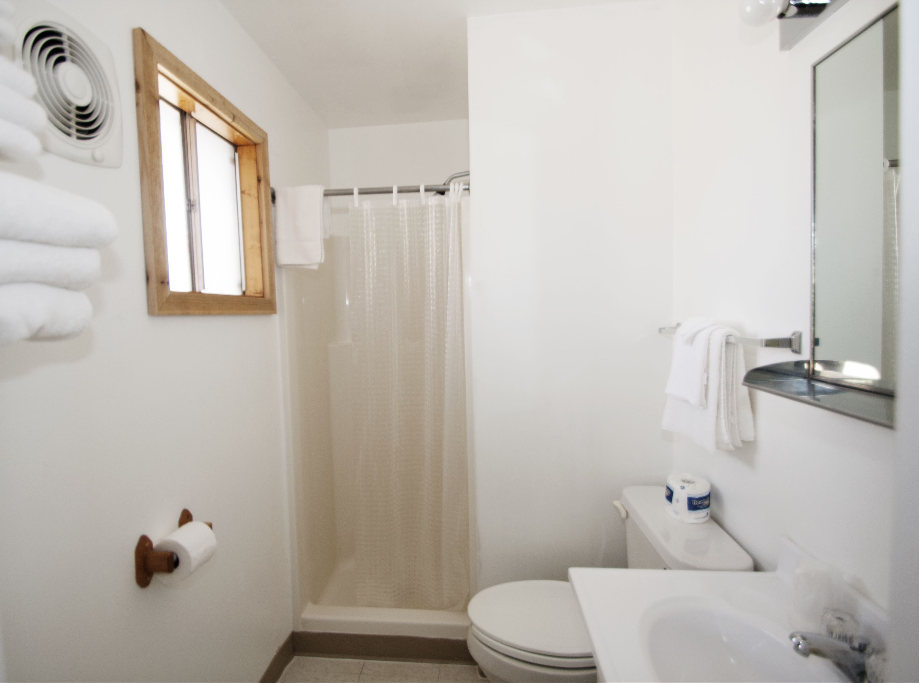Ein Badezimmer mit Toilette, Waschbecken, Duschvorhang und Handtuchhalter.