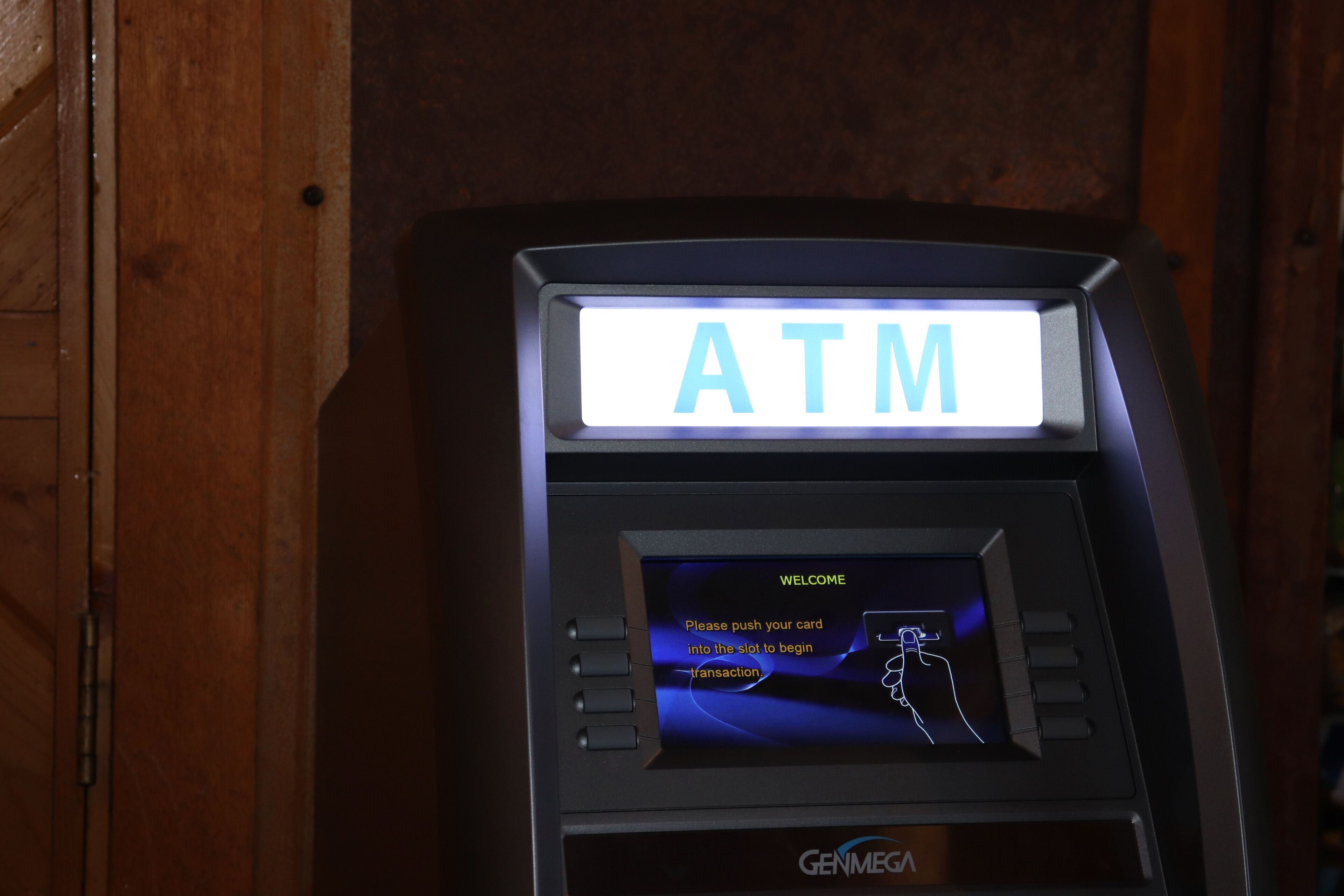 Een geldautomaat met een digitaal scherm en instructies voor het invoegen van een bankpas.