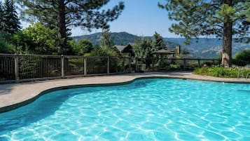 Una piscina al aire libre de temporada, sillones reclinables de piscina