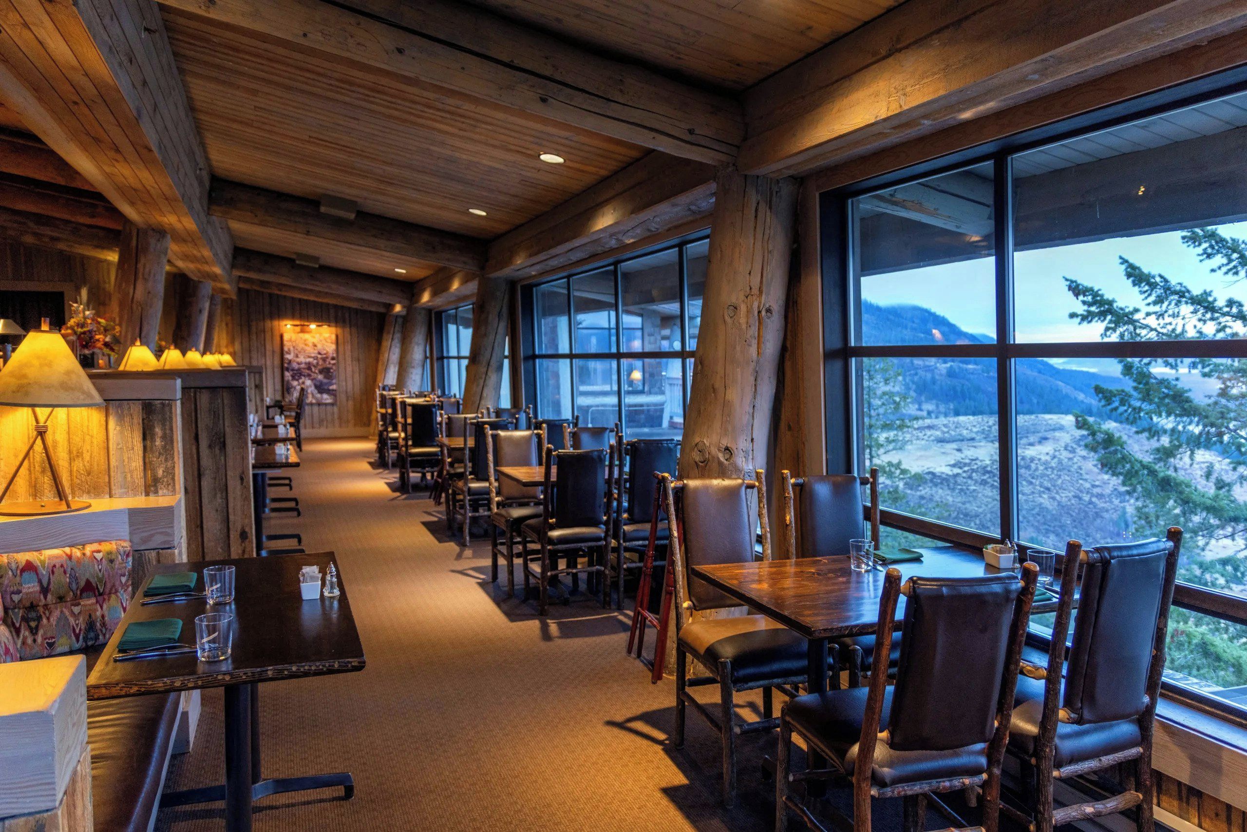 A cozy restaurant with wooden interiors and large windows offering mountain views.