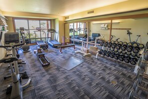 A gym with treadmills, elliptical machines, a bench, and a rack of dumbbells. - Sun Mountain Lodge (Winthrop)