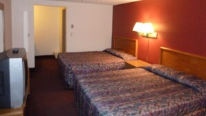 A hotel room with two beds, a desk, and a lamp. - Willow Springs Motel (Cheney)